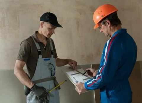 Worker and foreman discuss the scheme plasterboard ceiling Stock Photos