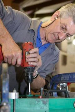 Worker and hand drill Stock Photos