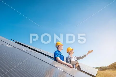 Worker and manager of solar farm looking into the sun Stock Photos