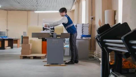 Worker and printing machine, polygraph industry Stock Photos