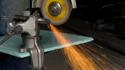 Worker with angular grinding machine is cutting the metal Stock Footage 76986911