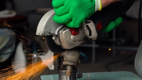 Worker with angular grinding machine is cutting the metal Stock Footage 77906988