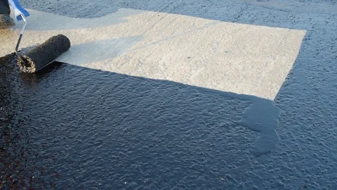 Worker applies bitumen mastic on the foundation Stock Footage 120480953