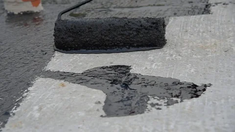 Worker applies bitumen mastic on the foundation Stock Footage 120481027