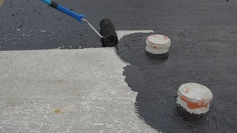 Worker applies bitumen mastic on the foundation Stock Footage 120481072