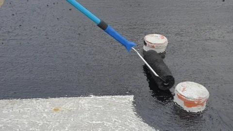 Worker applies bitumen mastic on the foundation Stock Footage 120511514