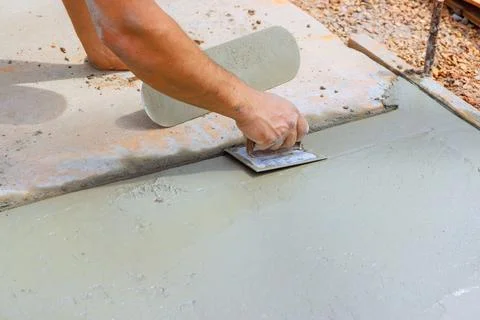 Worker applies concrete slab on surface during construction project Stock Photos
