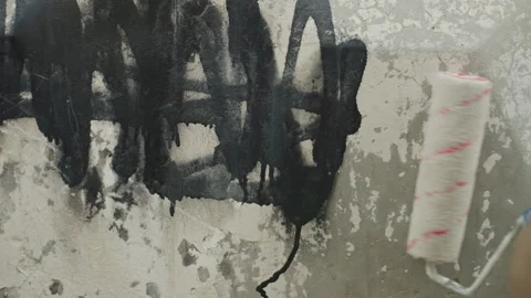 Worker applies fresh paint over graffiti on old facade. Individual methodically Vídeo Stock 332503304