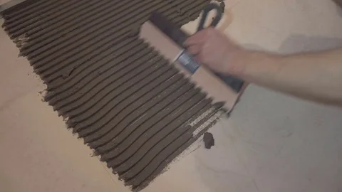 Worker applies glue for tiles Stock Footage 74058975