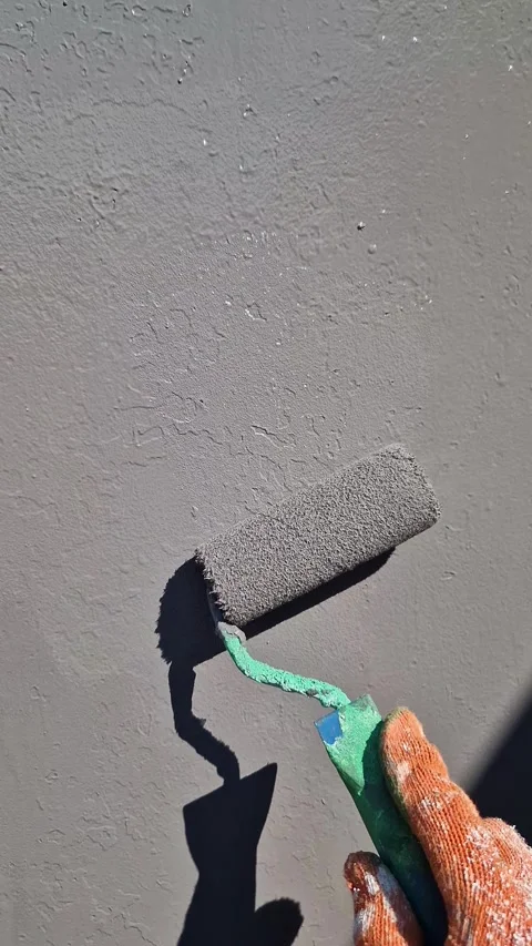 Worker Applies Grey Paint to Textured Wall with Roller in Close-Up Vertical Pov Stock Footage 338992381