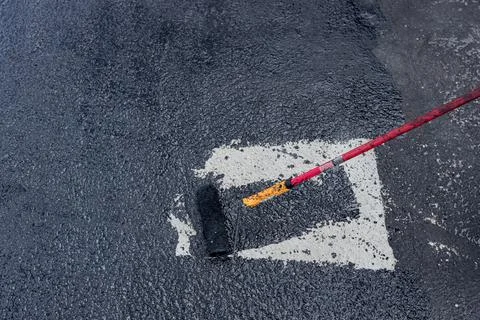 Worker applies one phase of waterproofing with a roller, the first basic Stock Photos
