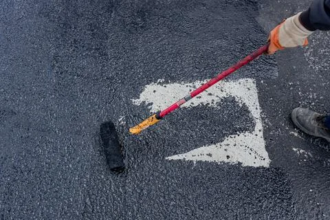 Worker applies one phase of waterproofing with a roller, the first basic Stock Photos