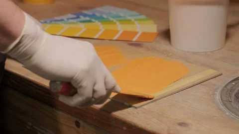 A worker applies a paint sample to a palette for color verification Stock Footage 170200130