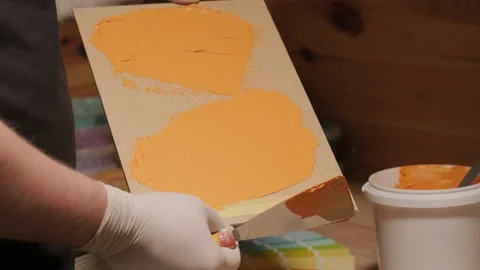 A worker applies a paint sample to a palette for color verification Stock Footage 170616074