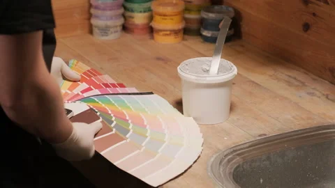 A worker applies a paint sample to a palette for color verification Stock Footage 171632334