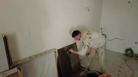 Worker applies plaster to wall in construction area while preparing place for fi Stock Footage 332365409