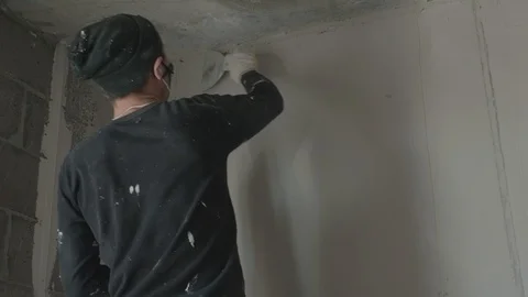 Worker apply plaster on the wall in pandemic Stock Footage 130049113