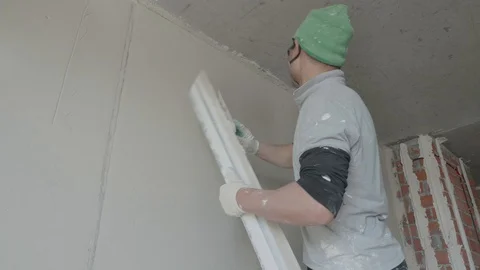 Worker apply plaster on the wall in pandemic Stock Footage 130049253
