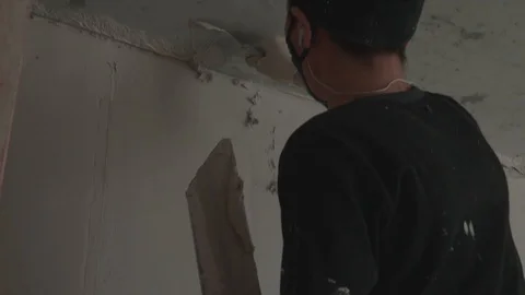 Worker apply plaster on the wall in pandemic Stock Footage 130049316