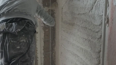 Worker apply plaster on the wall in pandemic Stock Footage 130049385