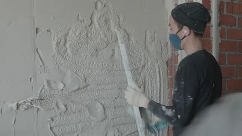 Worker apply plaster on the wall in pandemic Stock Footage 130049498