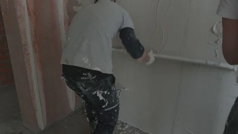 Worker apply plaster on the wall in pandemic Stock Footage 130049728