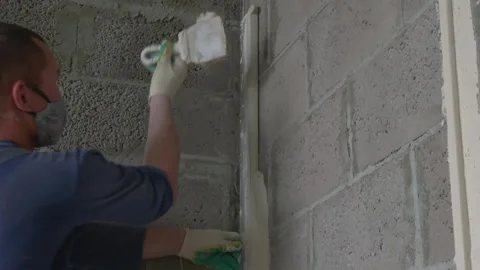 Worker apply plaster on the wall in pandemic 14.05.2020 Stock Footage 130426178
