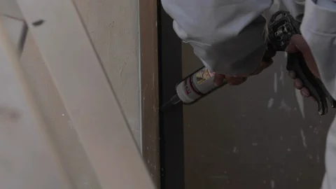 Worker applying black silicone sealing with caulking gun for moisture protection Видео 110771432