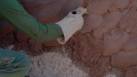Worker applying cement and sand plaster by hand to a rustic masonry wall in Stock Footage 343343061