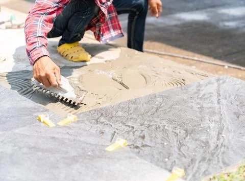 Worker applying ceramic tile adhesive on the floor Foto stock
