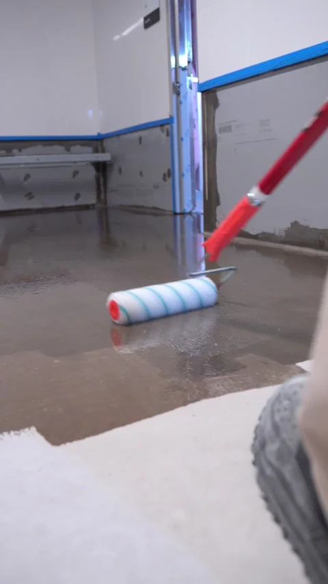 Worker applying epoxy floor coating with roller 库存影片 320921512