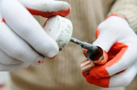 A worker is applying flux. Stock Photos