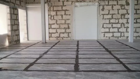 Worker applying grout between tiles on floor 스톡 사진