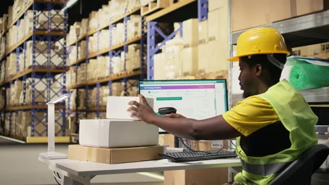 Worker applying labels and scanning tracking info numbers on barcodes tags Stock Footage 315707033