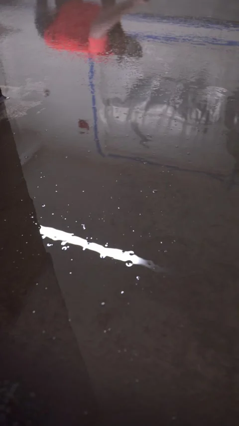 Worker applying liquid layer on floor, reflected in wet glossy surface. 스톡 동영상 323772582