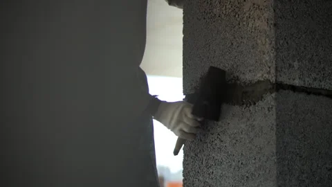 Worker applying mortar between concrete wall blocks Stock Footage 318779720