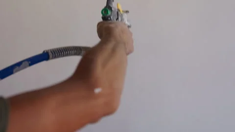 Worker applying plaster to interior wall using mechanical spray gun Stock-Footage 347733642
