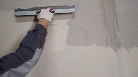 Worker applying plaster to wall with trowel Stock Footage 338385336
