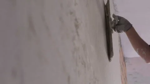 Worker applying plaster to wall with trowel during interior finishing Stock Footage 346550808