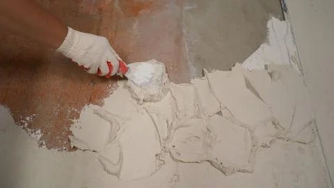 Worker applying plaster to wall with trowel, construction and renovation concept Stock Photos