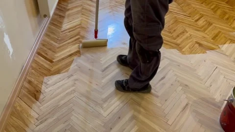 A worker is applying a scraper polish to a parquet that has deteriorated. Stock Footage 244794623
