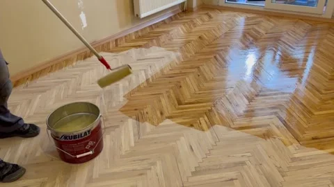 A worker is applying a scraper polish to a parquet that has deteriorated. Stock Footage 244794706