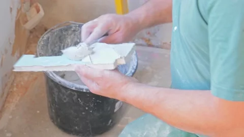 Worker applying skim coating material to plasterboard wall Stock Footage 142952092
