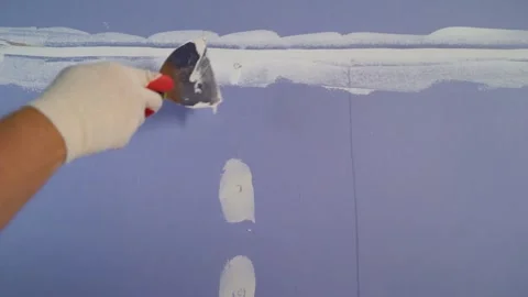 Worker applying spackle to drywall seam Stock Footage 329924693