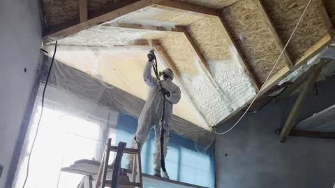 Worker applying spray polyurethane foam insulation Stock Footage 323409898