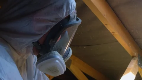 Worker applying thermal insulation in attic roof structure Stock Footage 342605183