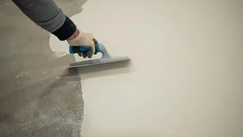 Worker Applying White Liquid Floor Coating With Roller and Trowel Stock Photos