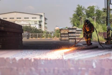 Worker are peeling the slab surface, Steel industry background. Stock Photos