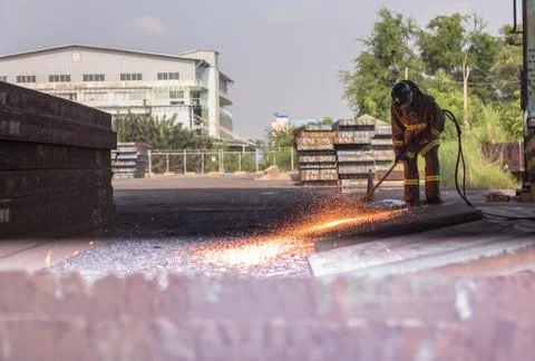 Worker are peeling the slab surface, Steel industry background. Stock Photos