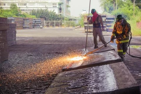 Worker are peeling the slab surface, Steel industry background. Stock Photos